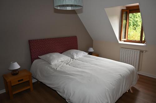 ein Schlafzimmer mit einem weißen Bett und einem Fenster in der Unterkunft La Villa du Papetier in Boussières