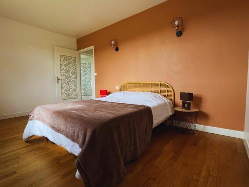 a bedroom with a large bed and a wooden floor at Le Robinson - Jusqu'à 7 couchages in Bourg-Fidèle