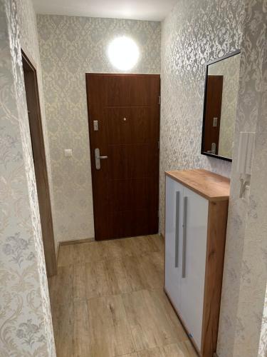 a room with a wooden door and a hallway with a kitchen at Sunny House Two in Bratislava