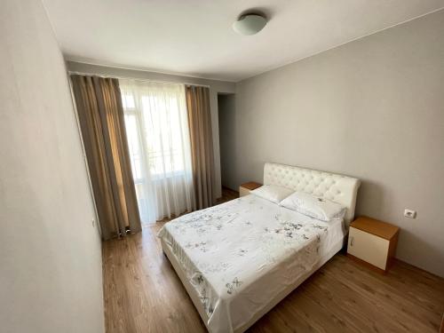 1 dormitorio con cama blanca y ventana en Varna City Apartment, en Varna