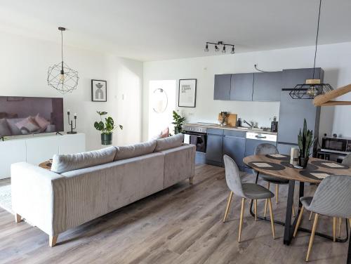 ein Wohnzimmer und eine Küche mit einem Sofa und einem Tisch in der Unterkunft ViLiPa-Apartments modernes Wohnen mitten im Zentrum am Bachhaus in Eisenach