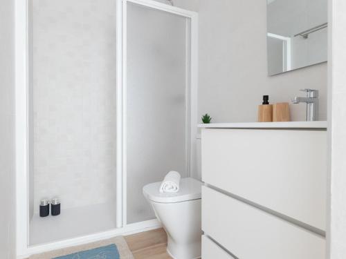 a white bathroom with a toilet and a shower at Matarolux24 in Mataró