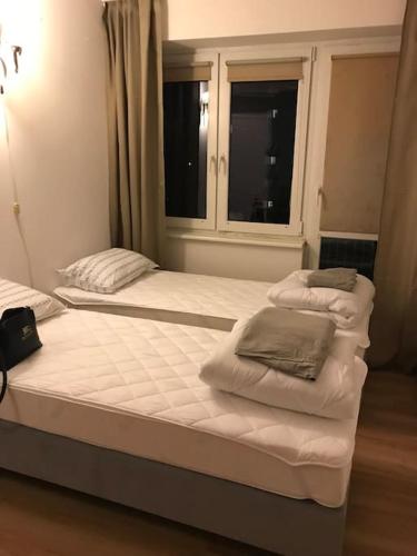 two beds in a room with a window at Przytulny apartament z bezpłatnym parkingiem in Olsztyn