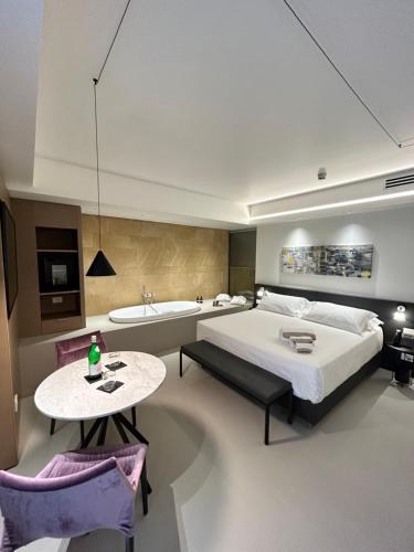 Palazzo Sangiorgio في كاتانيا: غرفة نوم بسرير وطاولة وحوض استحمام