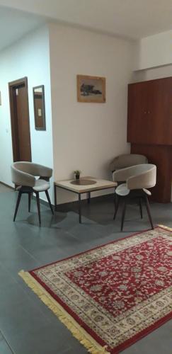 Habitación con 2 sillas, mesa y alfombra. en Garni hotel Niksic en Nikšić