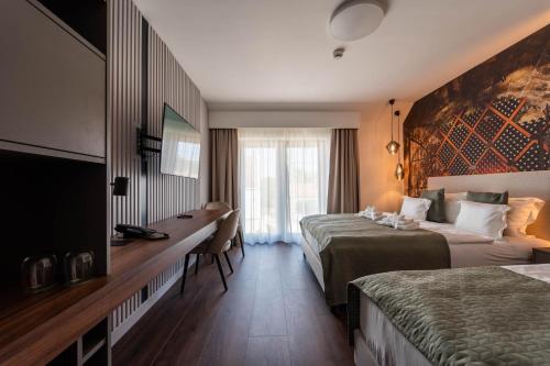エチャクにあるRókusfalvy Borhotel és Fogadóのベッド2台とデスクが備わるホテルルームです。