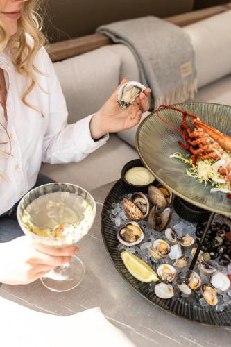 a woman sitting at a table with plates of food at Pillows Grand Boutique Hotel Maurits at the Park - Small Luxury Hotels in Amsterdam