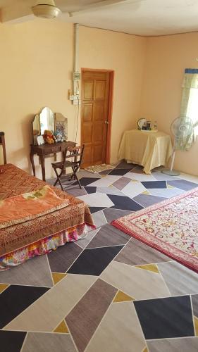 a room with two beds and a checkered floor at Roomstay "Ghumah Uwan" in Batu Kikir