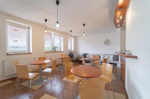 Penzión Živa Bijacovce في Bijacovce: غرفة طعام مع طاولات وكراسي خشبية