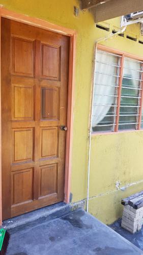 Una puerta de madera en una habitación con ventana en Roomstay "Ghumah Uwan" en Batu Kikir
