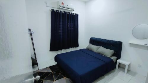 Cama azul en habitación con ventana en FIRASH HOMESTAY AT SERI ISKANDAR en Seri Iskandar