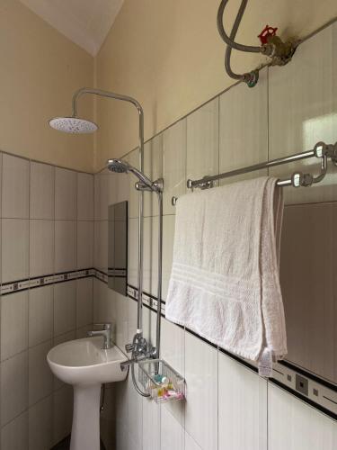 a bathroom with a sink and a white towel at Rafiki Safari Lodge Bwindi in Kinkizi