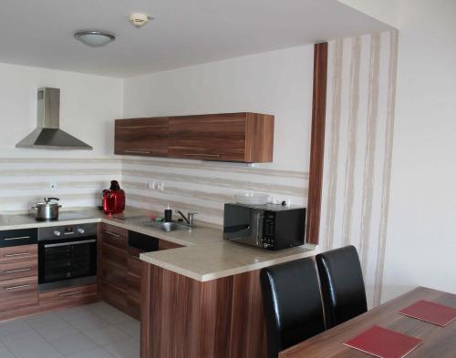 a kitchen with a sink and a microwave at Apartman MARLEA in Donovaly