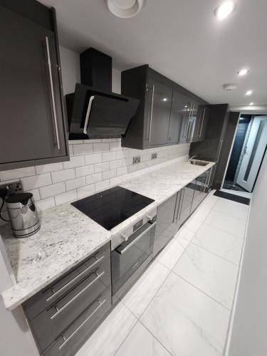 a kitchen with black and white marble counter tops at Billie Island apartments in Slaithwaite