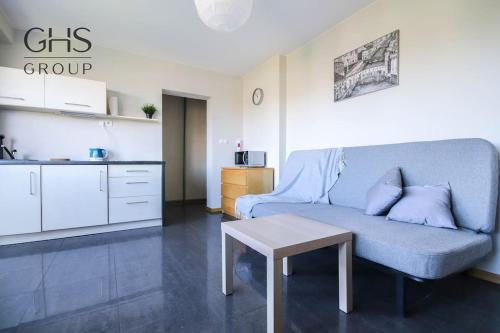 ein Wohnzimmer mit einem Sofa und einem Tisch in der Unterkunft Przytulny apartament w centrum Krakowa in Krakau
