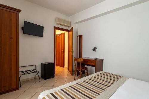 a bedroom with a bed and a desk and a television at A Casa Dei Gonzaga, MantegnaHotels in Mantova