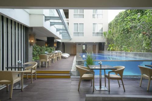 a restaurant with tables and chairs and a swimming pool at Solaris Hotel Kuta in Kuta