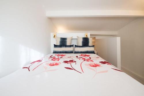 - une chambre avec un lit orné de fleurs rouges dans l'établissement Le Goélette - Superb cosy apartment, à Lyon