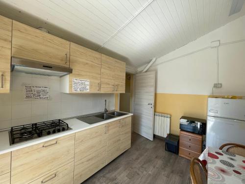 a kitchen with wooden cabinets and a white refrigerator at Casa Per Ferie San Giovanni Bosco in La Spezia