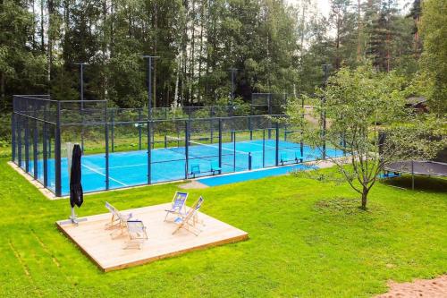 uma piscina com duas cadeiras e um cesto de voleibol em Villa Padel - Premium Lakeside Residence & Grounds em Lohja