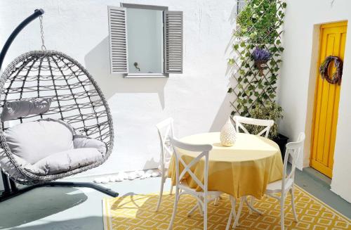 a patio with a table and chairs and a swing at DION'S HOME with Private Parking at the Center of Kos Town in Kos