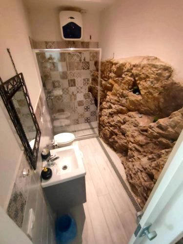 a bathroom with a rock shower and a sink at The small waterfall house, la cascatella in Massa
