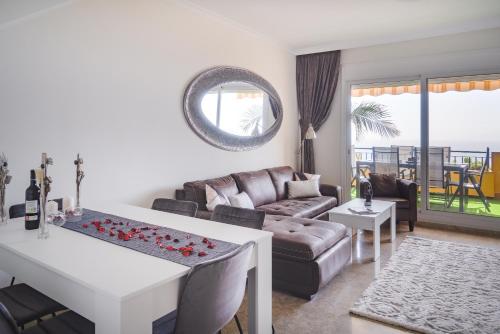 una sala de estar con un sofá y una mesa en Belvedere Penthouse, en Puerto de Santiago
