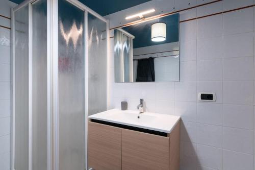 a white bathroom with a sink and a shower at CASOLARA: ospitalità su misura in Castello di Serravalle