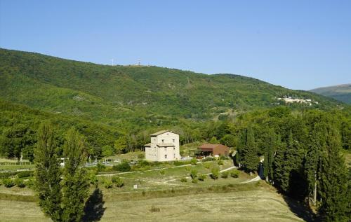 ein Haus inmitten eines Feldes mit Bäumen in der Unterkunft Agriturismo Colle Casini Cortesi in Caldarola