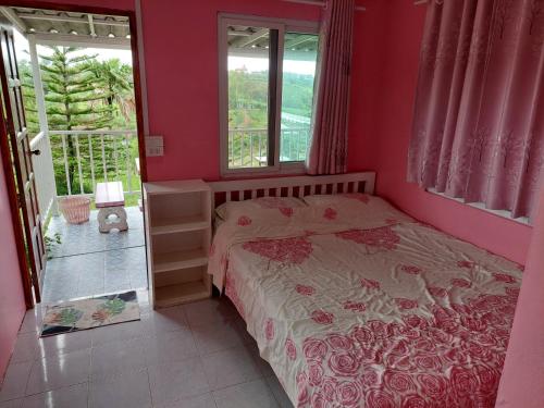 a bedroom with a bed and two windows at Lovely Farm in Khao Kho