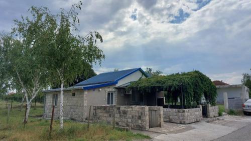 een klein huis met een blauw dak bij Apartments Airport Golubovci 2 in Podgorica