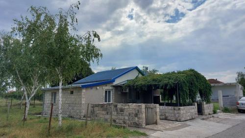 a small house with a blue roof at Apartments Airport Golubovci 2 in Podgorica