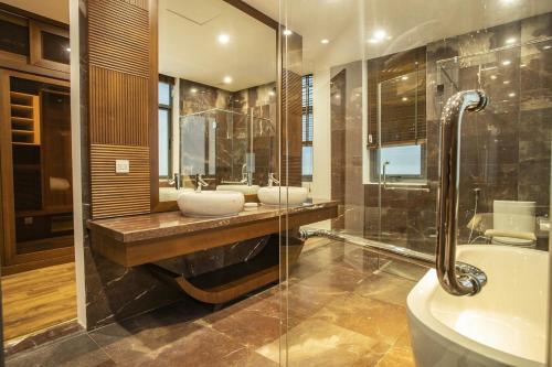 a bathroom with two sinks and a tub and a shower at Sea Villa - FLC Sam Son in Sầm Sơn