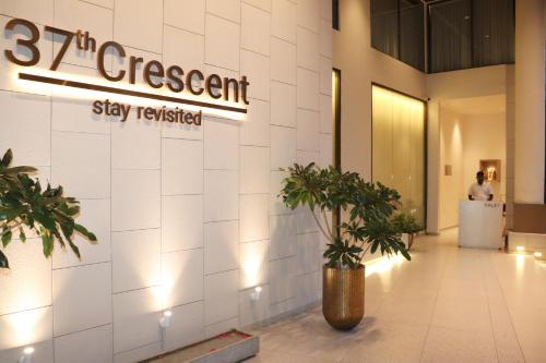a lobby with a sign that reads percentstay satisfied at 37th Crescent Hotel Bengaluru in Bangalore
