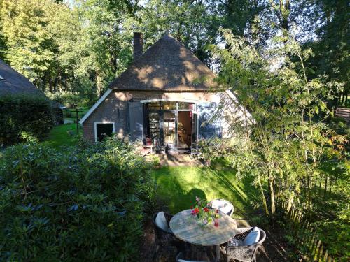 a small cottage with a table in front of it at Landgoedhoeve Vosbergen in Heerde