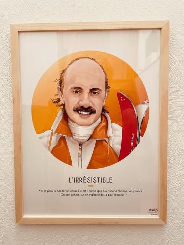a framed poster of a man with a surfboard at La Gouleote Spacieuse maison type chalet avec jacuzzi, sauna, pétanque in Gérardmer