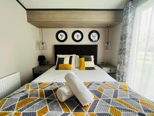 ヨークにあるTeejay's Lodge with Hot Tubのベッドルーム1室(壁に時計2台が付いたベッド1台付)