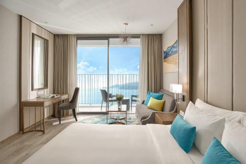Pokój hotelowy z łóżkiem, biurkiem i pokojem w obiekcie SeaScape Panorama Grand Resicedences Nha Trang w mieście Nha Trang