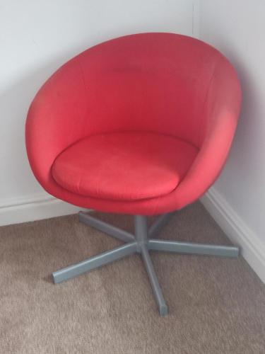 a red chair sitting in a corner of a room at Madif Ensuite in Leicester