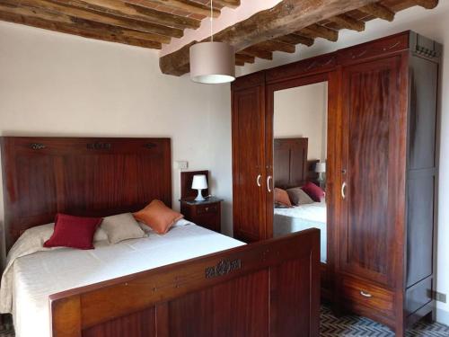 1 dormitorio con cama de madera y espejo en La casa dei nonni, en Lucca