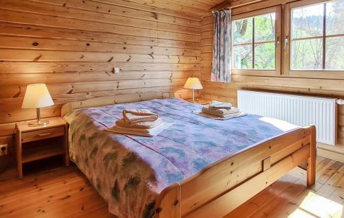 a bedroom with a large bed in a log cabin at Werrapark Resort Ferienhäuser Am Sommerberg in Masserberg