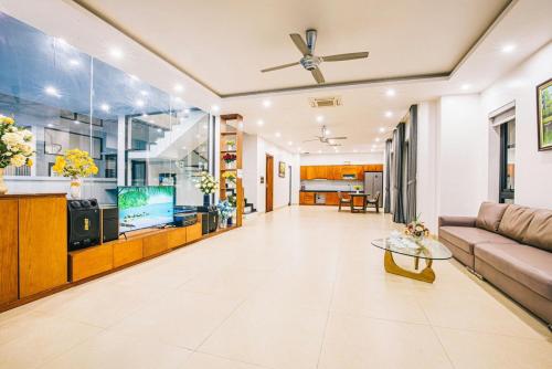 a living room with a couch and a tv at Sea Villa - FLC Sam Son in Sầm Sơn