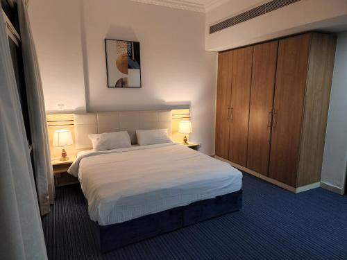 a bedroom with a bed with two lamps and a cabinet at Havana Holiday Homes Oud Metha in Dubai