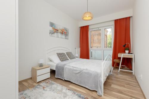 1 dormitorio con cama blanca y ventana en Apartment with Balcony & Parking Near Manufaktura Łódź by Renters Prestige, en Łódź