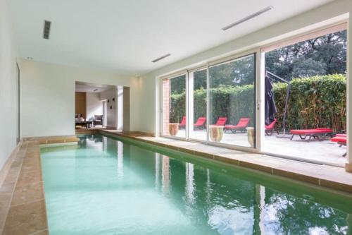 - une piscine vide dans une maison avec fenêtres dans l'établissement Cottage spacieux Domaine de la Bretesche, à Missillac