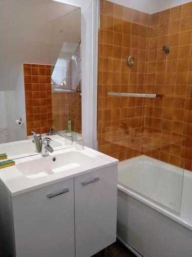 une salle de bain avec un lavabo, une douche et une baignoire dans l'établissement Cottage spacieux Domaine de la Bretesche, à Missillac