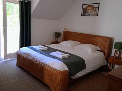 - une chambre avec un lit et 2 serviettes dans l'établissement Cottage spacieux Domaine de la Bretesche, à Missillac