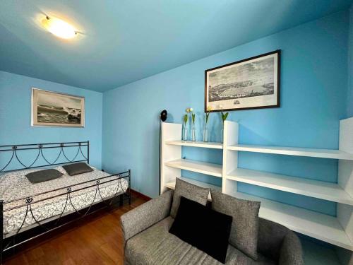 een blauwe kamer met een bed, een bank en planken bij Charlotte Deluxe Apartment 2 in Trieste