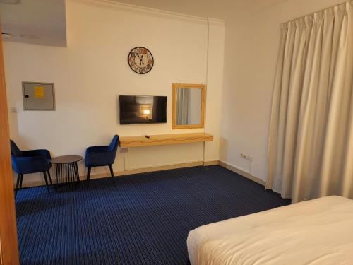 a hotel room with a desk and a clock on the wall at Havana Holiday Homes Oud Metha in Dubai