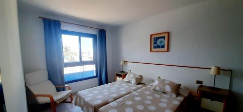 - une chambre avec un lit, une chaise et une fenêtre dans l'établissement Villa Suculenta, à Playa Blanca
